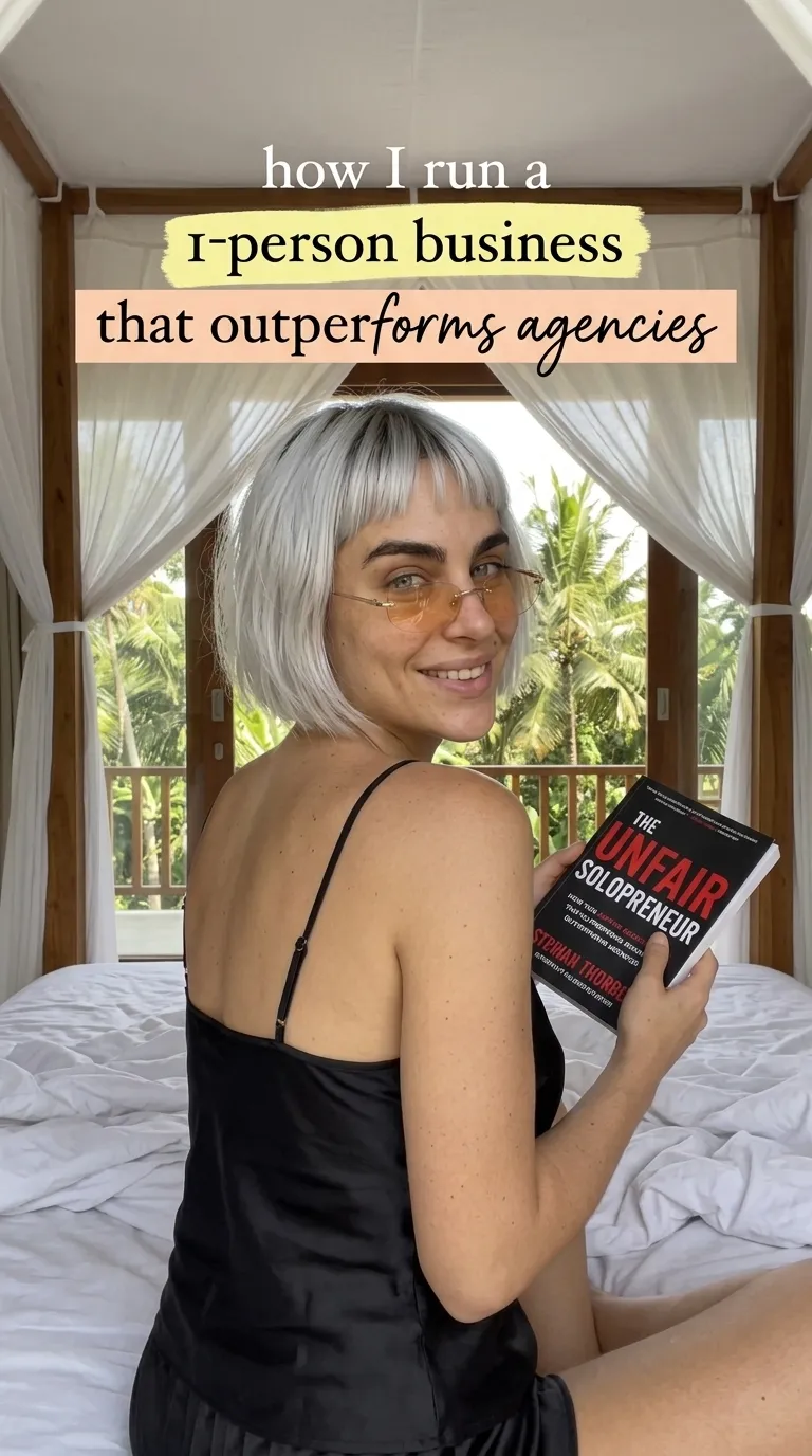 Woman holding The Unfair Solopreneur in a bedroom