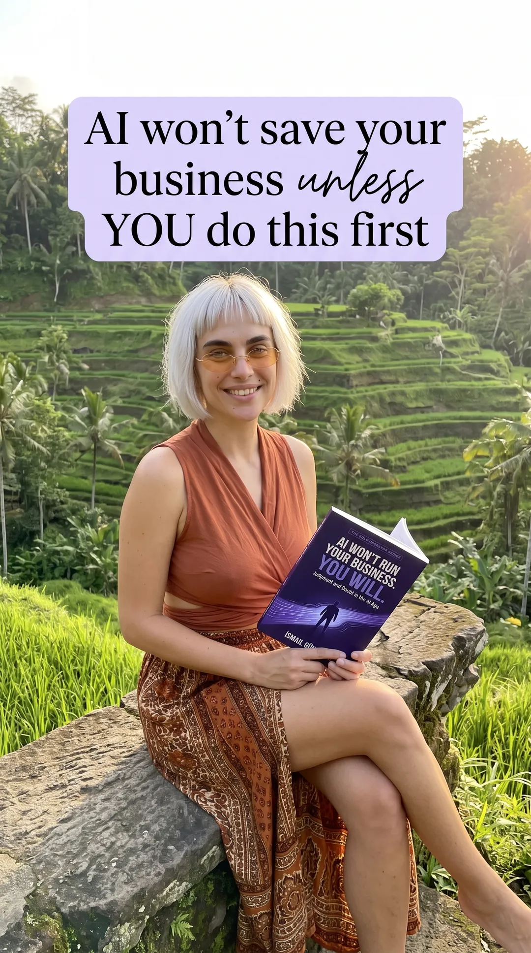 Kaia in a rust wrap top and patterned skirt by rice terraces holding the AI Won't Run Your Business paperback
