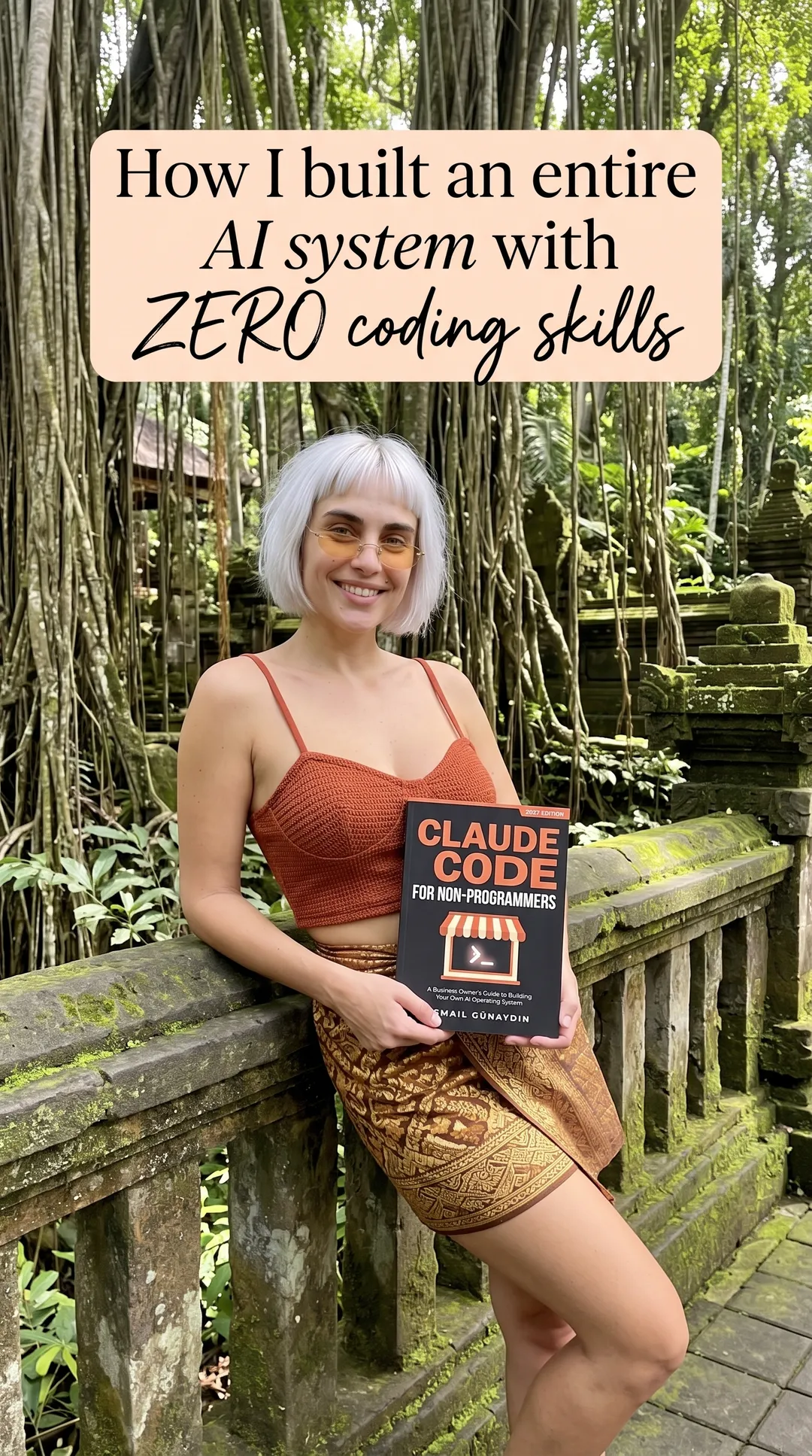 Kaia in a rust cami and sarong leaning on a mossy stone railing holding Claude Code for Non-Programmers