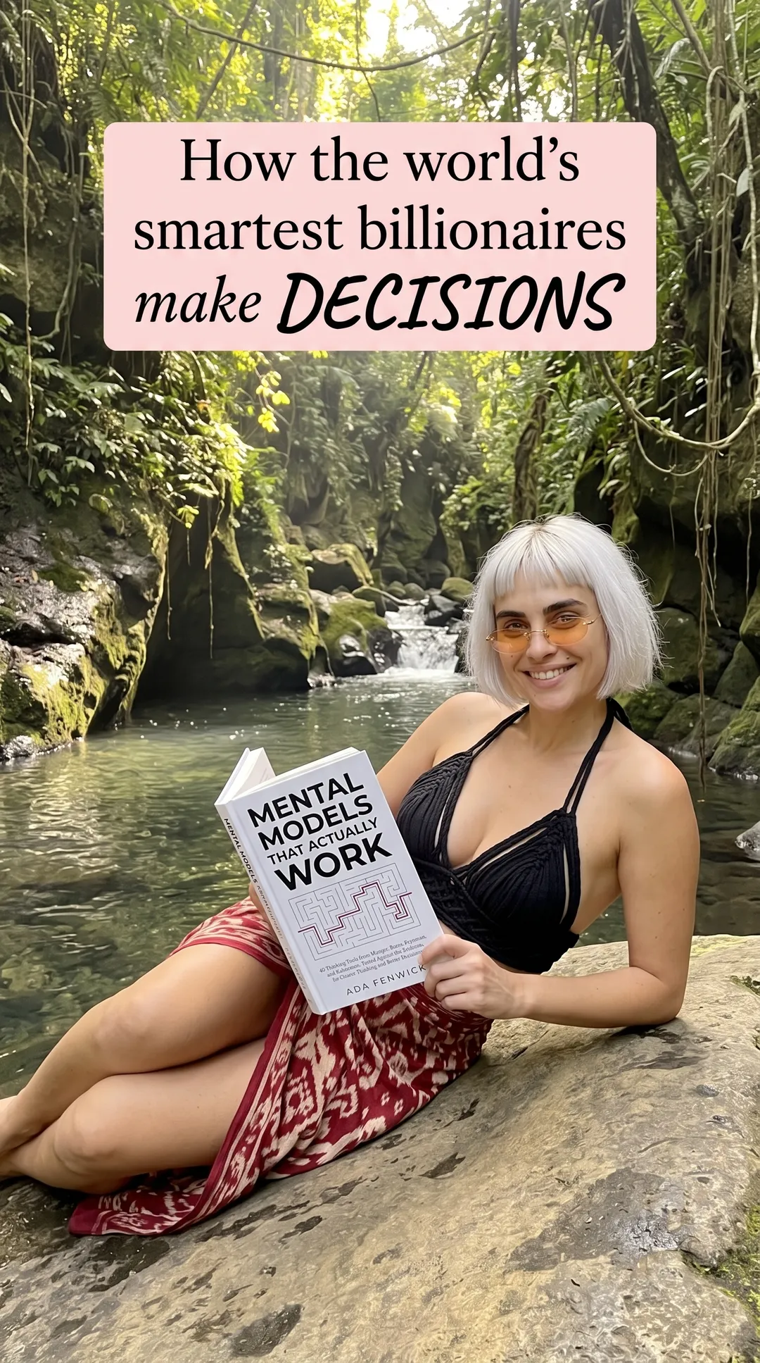 Kaia in a black swimsuit and red sarong on a river rock holding Mental Models That Actually Work