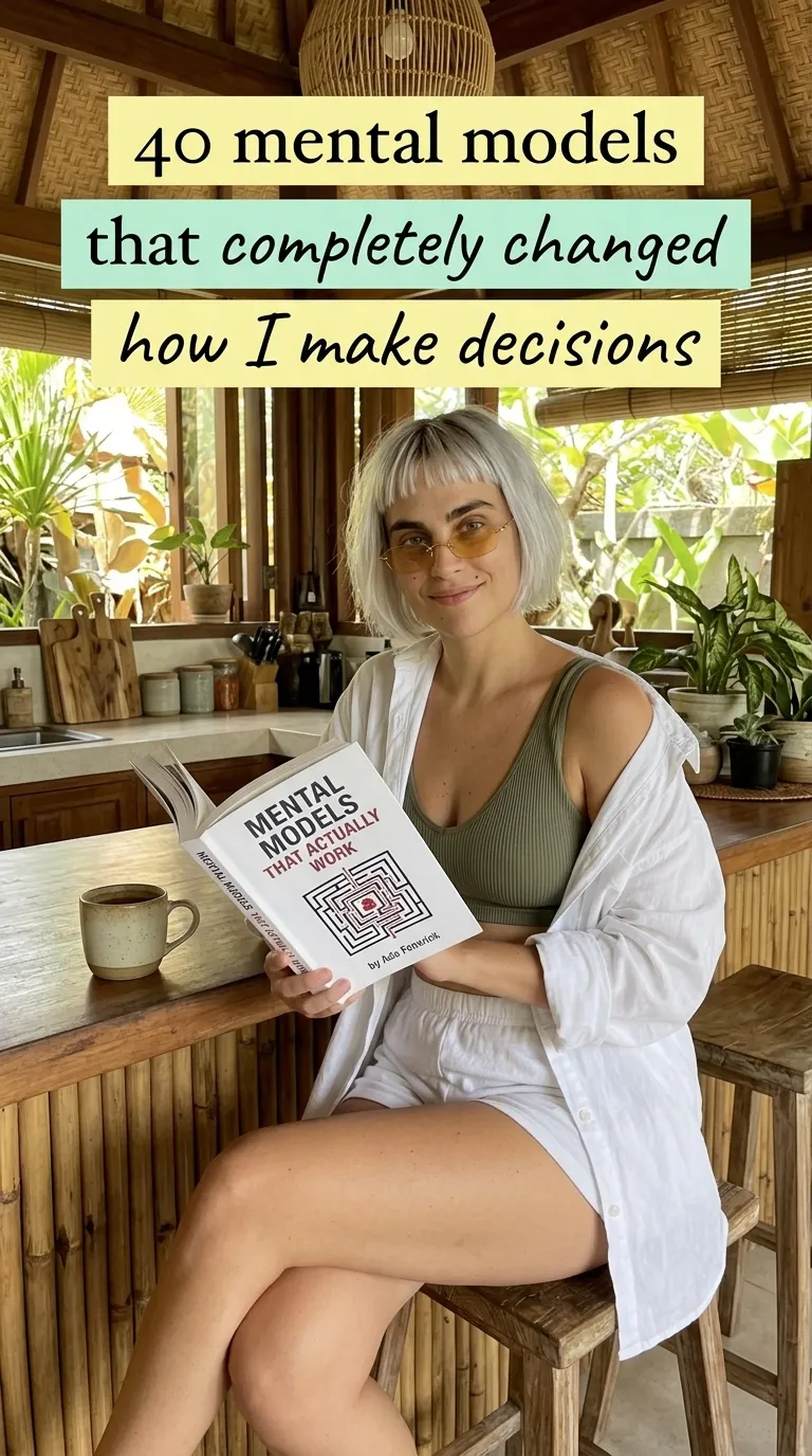 Kaia in a white shirt on a cafe bar stool holding open Mental Models That Actually Work